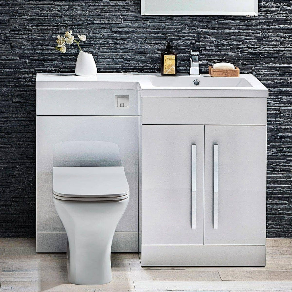 Sleek white bathroom vanity with integrated toilet and sink, modern minimalist design, black textured wall backdrop, bathroom accessories, typical of Bubly Bathrooms.