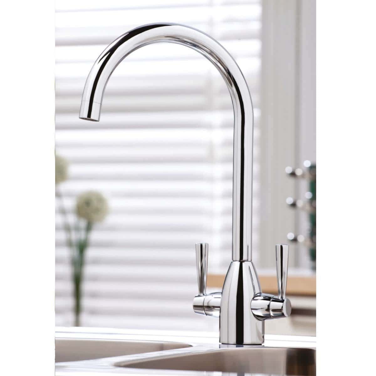 Shiny chrome kitchen taps in modern bathroom setting, close-up view.