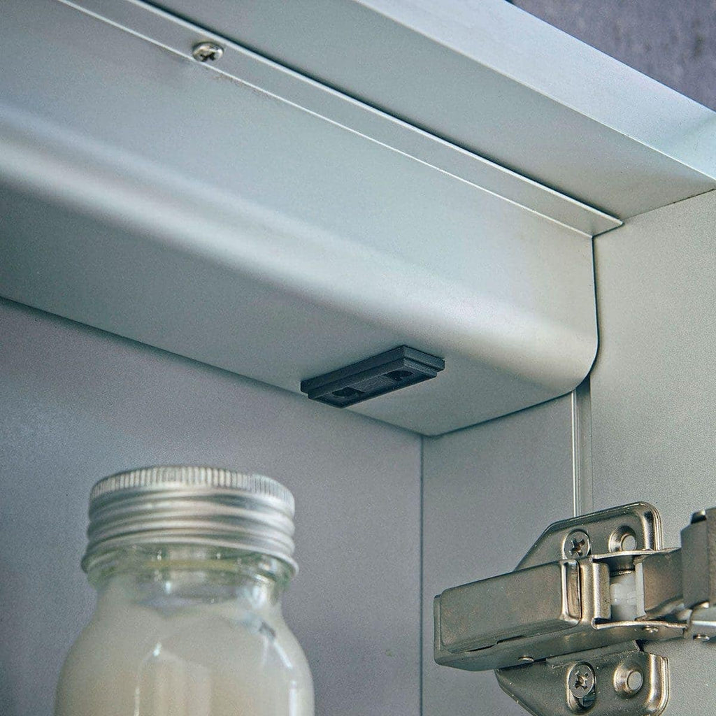 Light grey bathroom cabinet hinge with soft-close mechanism, close-up imagery; modern cabinetry hardware by Bubly Bathrooms.