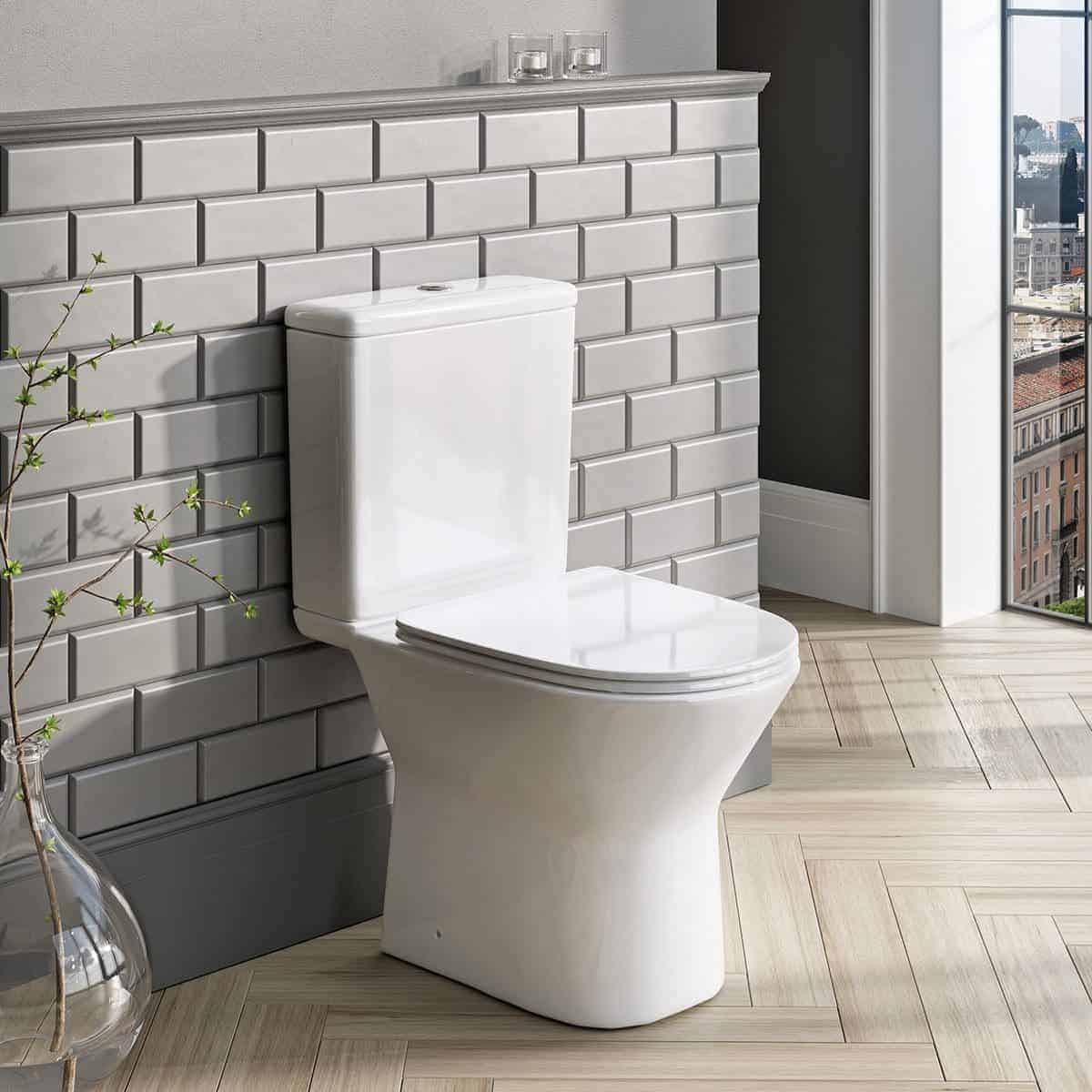 Sleek white ceramic toilet in modern bathroom with grey subway tile wall, natural light, and city view, showcasing premium bubly bathroom fixtures and contemporary design.