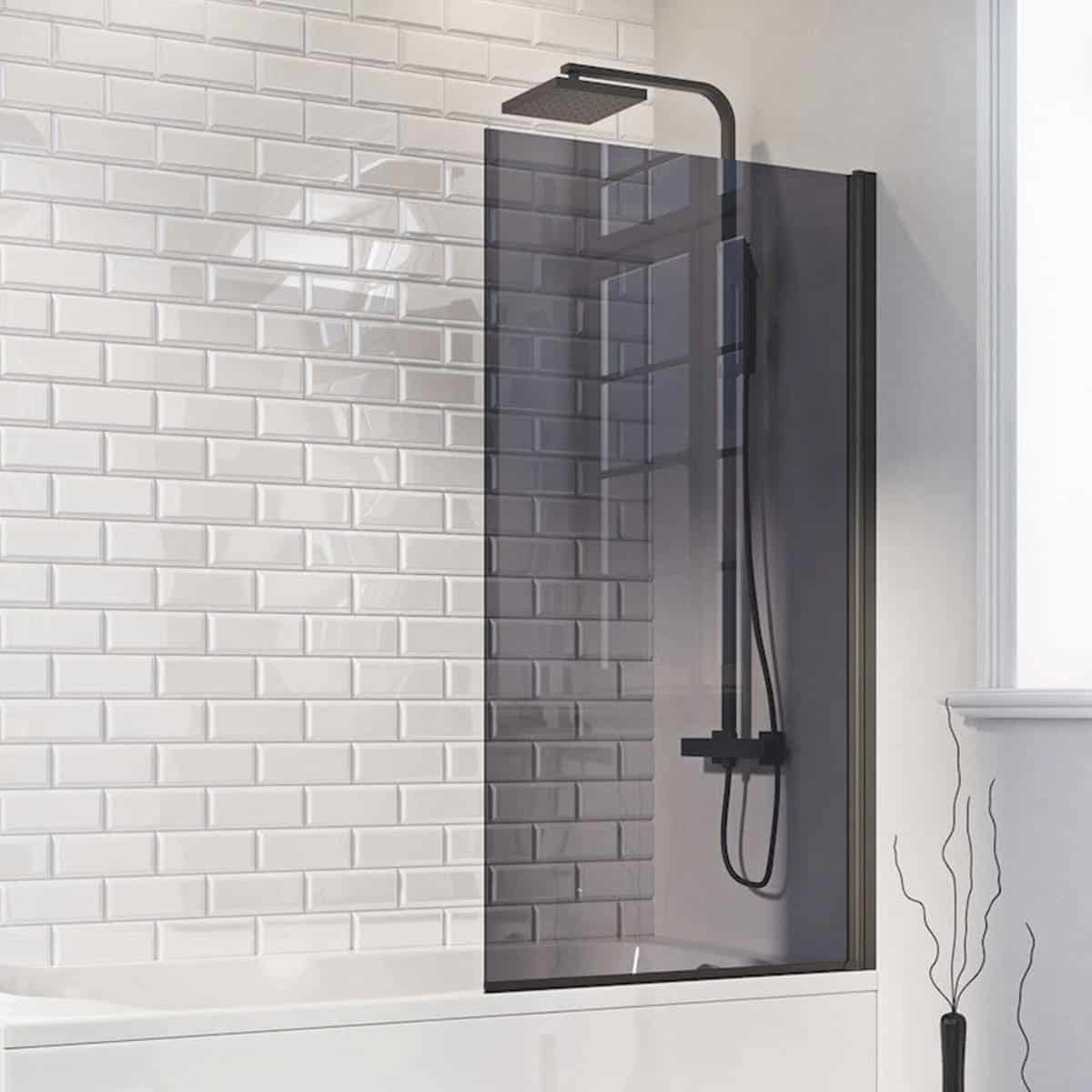 Shower enclosure with black panel and rainfall showerhead in modern bathroom with white subway tiles.