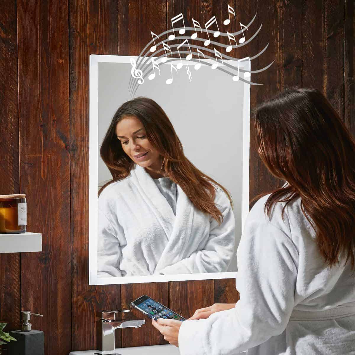 Relaxed woman in a white bathrobe looking into a mirror with musical notes above her head, indicating enjoyment or singing in the bathroom.