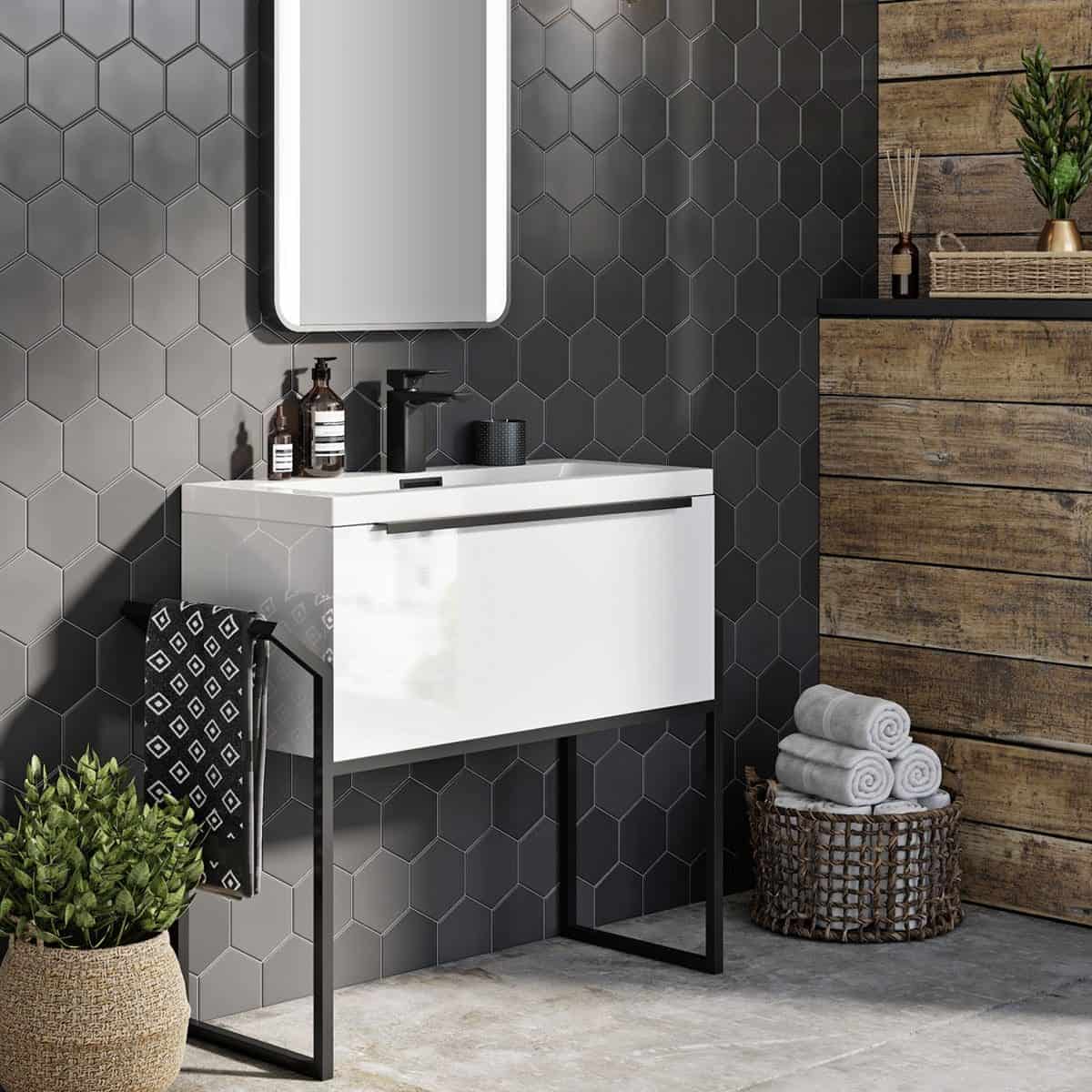 Sleek modern bathroom vanity with black fixtures and hexagon wall tiles in a contemporary bathroom setting. Wooden accents and fresh towels create a stylish, functional space.