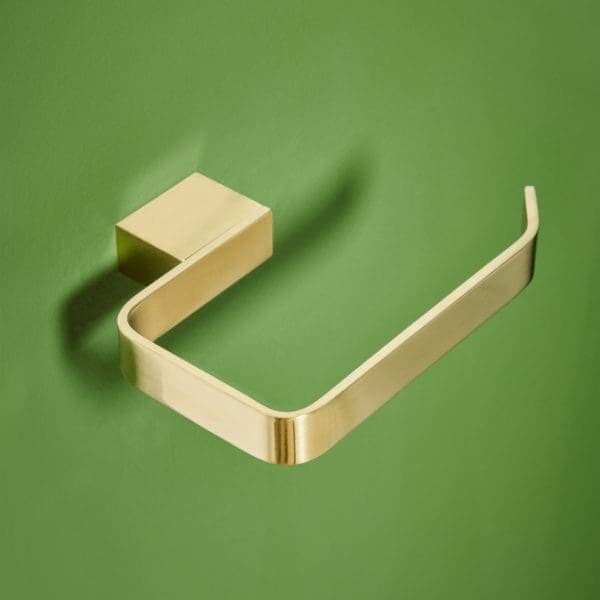Modern towel ring in brass finish mounted on green bathroom wall, stylish and functional bathroom accessory.
