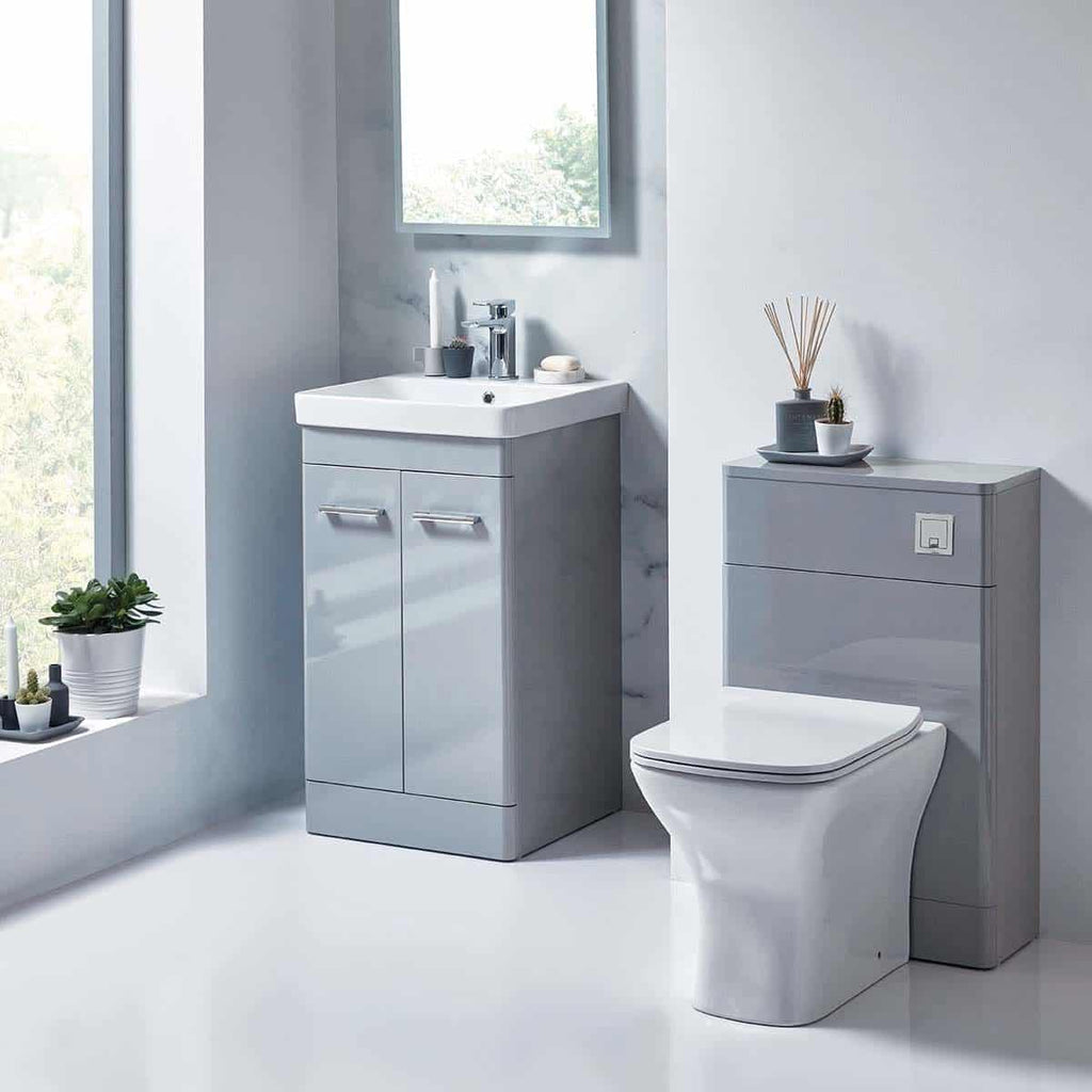 Sleek grey bathroom vanity with integrated sink and modern toilet in a contemporary minimalist bathroom setting. Features clean lines and ample storage for a stylish, functional space.