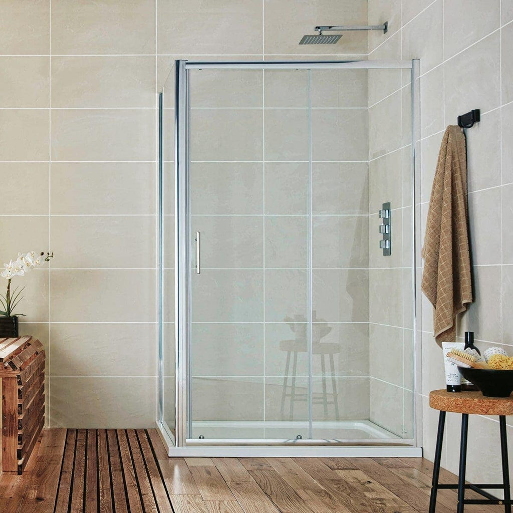 Shower enclosure with glass doors and modern controls in a contemporary bathroom with beige tiled walls and wooden floor tiles, featuring a towel hook and small side table with toiletries, designed for stylish bathing spaces.