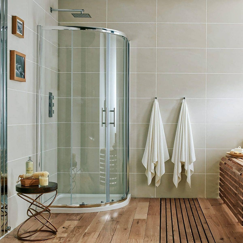 Elegant modern shower enclosure with glass doors in a contemporary bathroom featuring beige tiled walls and wooden accents. Ideal for stylish bathroom renovations and spa-like bathroom design.
