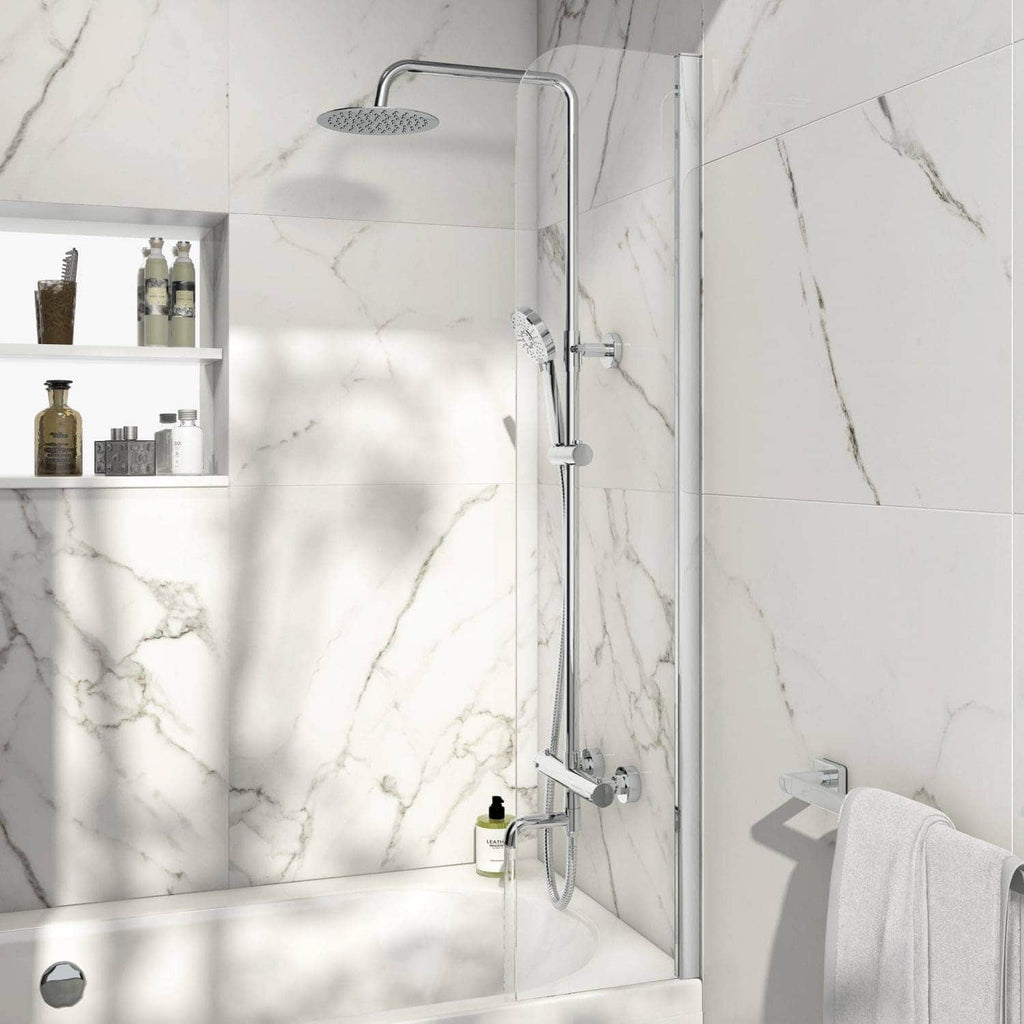 Shower with contemporary chrome fixtures in a white marble-tiled bathroom featuring a built-in shelf for toiletries and a white towel on a wall hook.