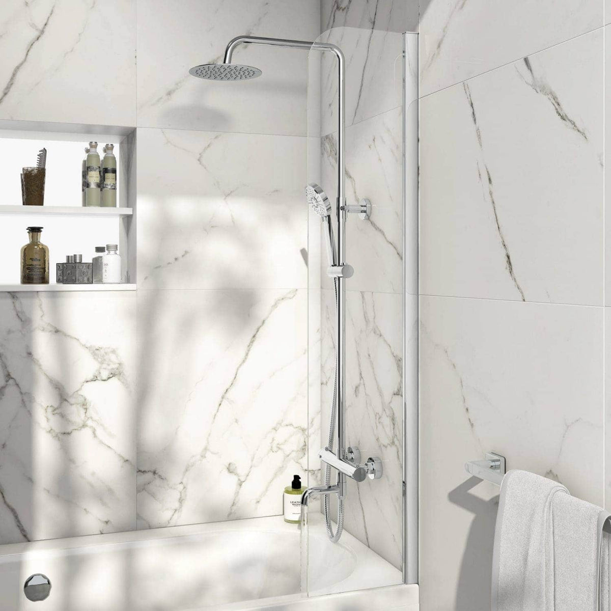 Shower with contemporary chrome fixtures in a white marble-tiled bathroom featuring a built-in shelf for toiletries and a white towel on a wall hook.