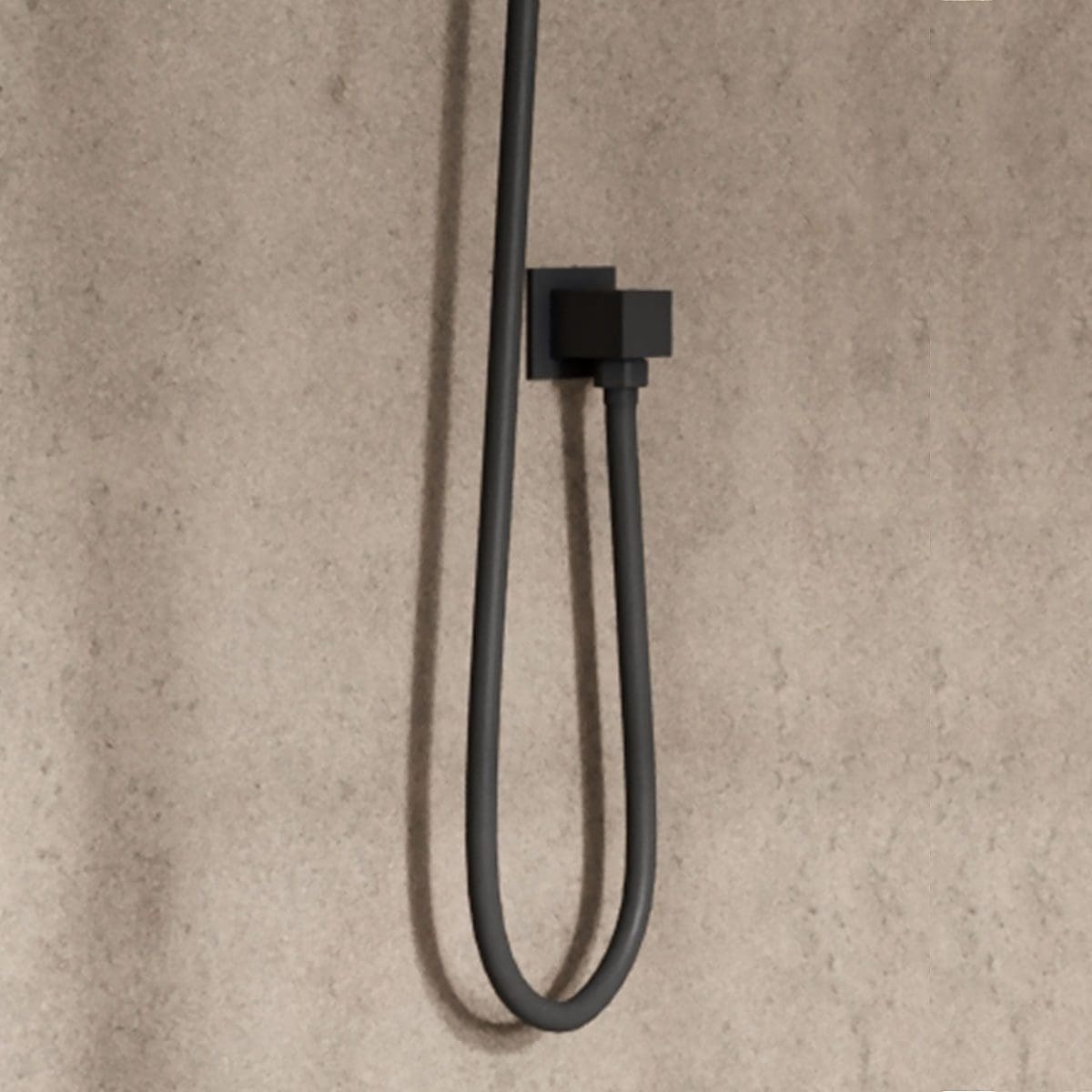 Flexible black shower hose with wall mount holder on beige bathroom wall.