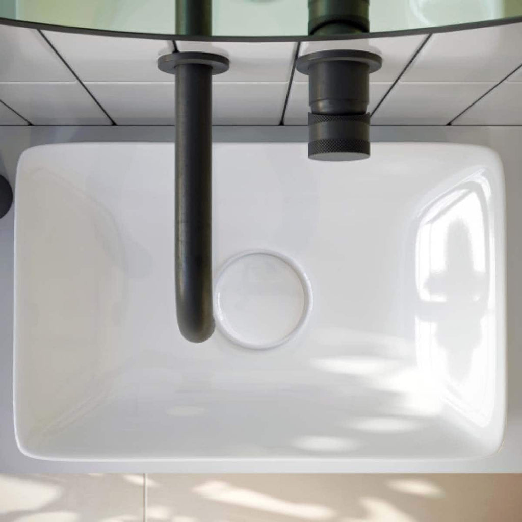 Sleek white bathroom countertop with black plumbing fixtures, modern design, and clean lines, ideal for contemporary bathroom renovation and plumbing installations.
