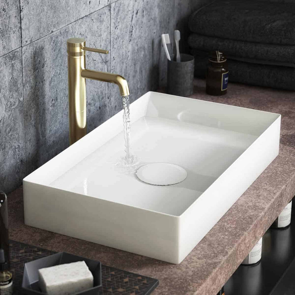Sleek modern bathroom sink with a gold tap and flowing water, set on a stone countertop. Perfect for contemporary bathroom designs, combining functionality with elegant style.