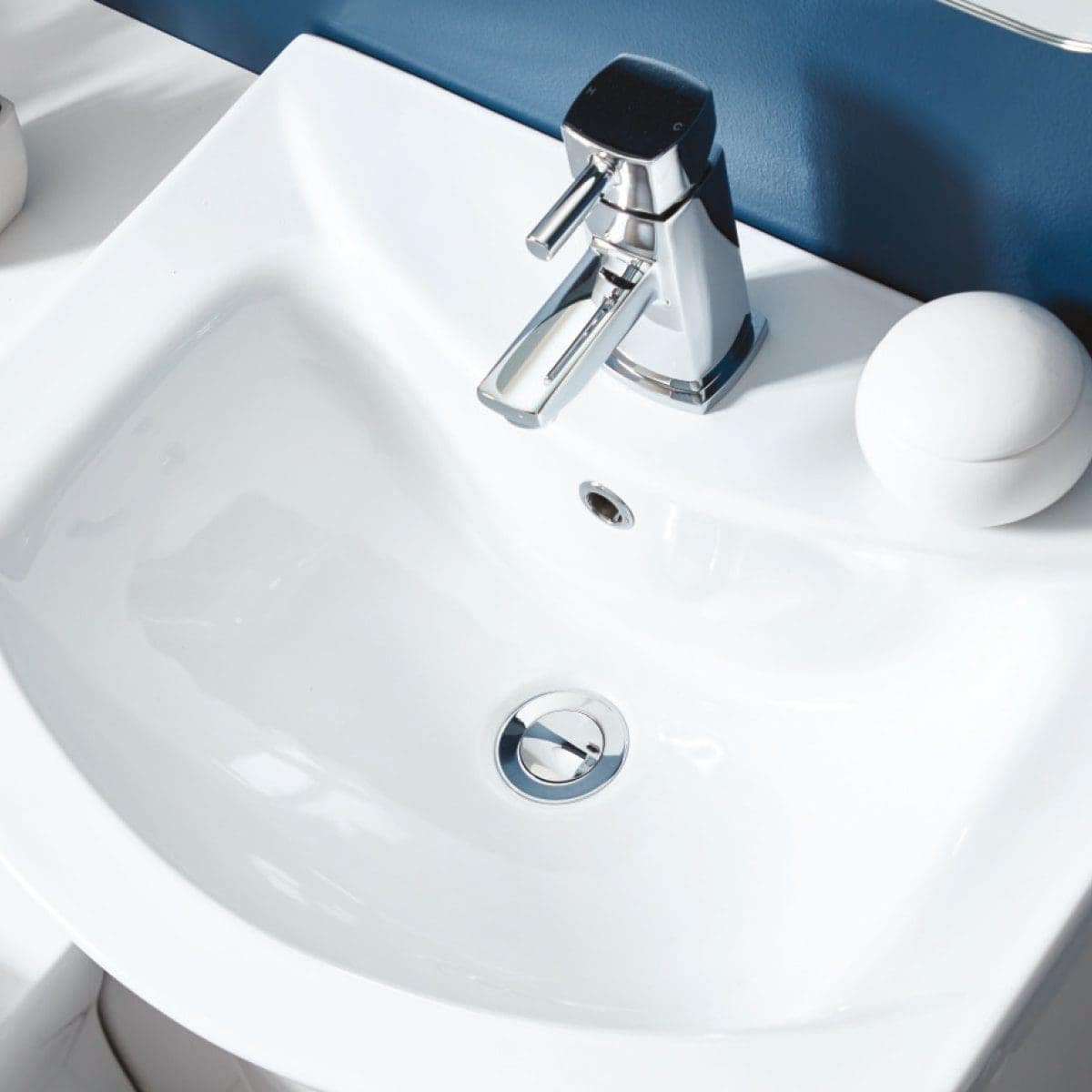 Modern white bathroom sink with chrome faucet and soap dispenser, stylish bathroom fixtures for contemporary bathroom design.
