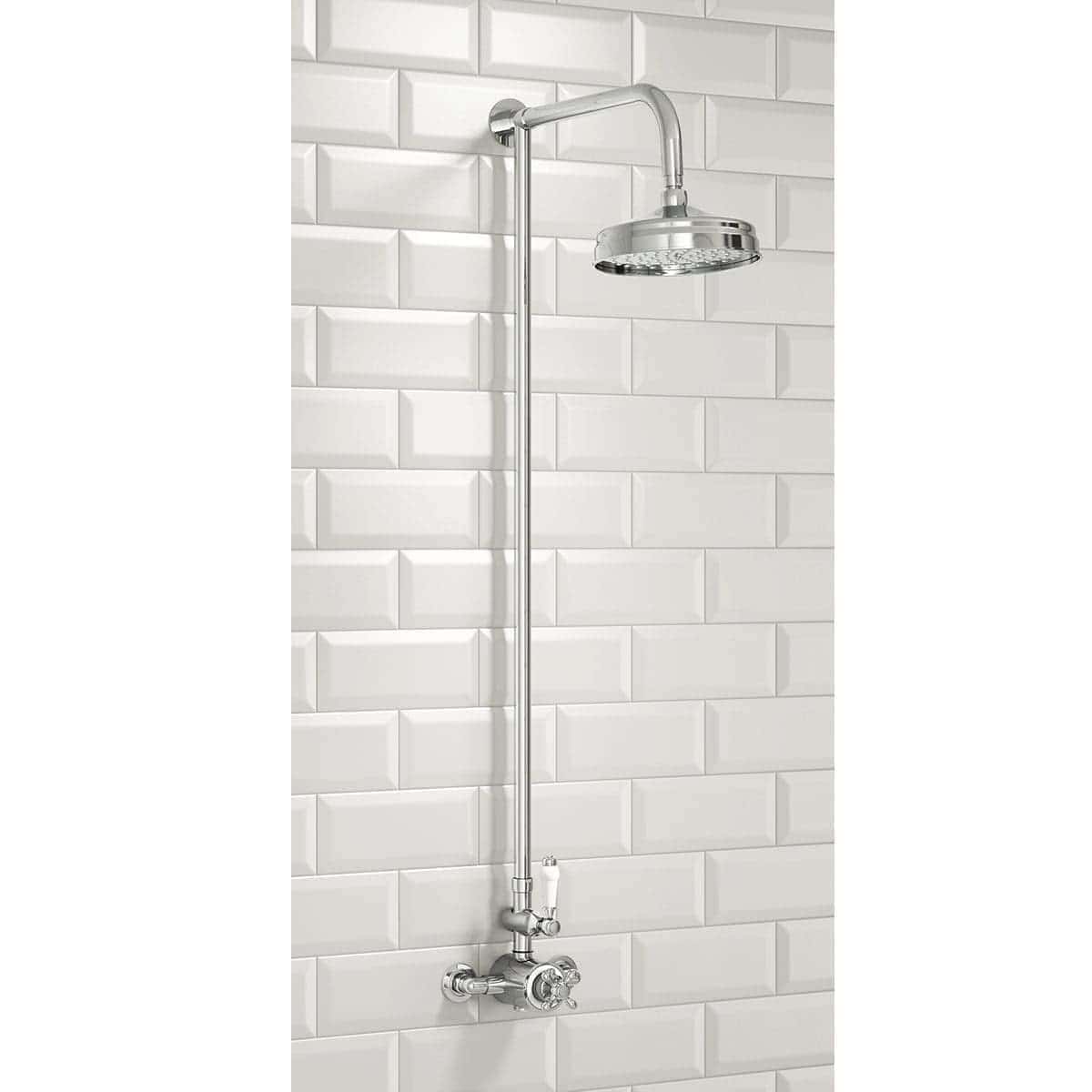 Polished chrome shower head with adjustable arm mounted on white tiled bathroom wall, modern plumbing fixture for luxury showering experience.