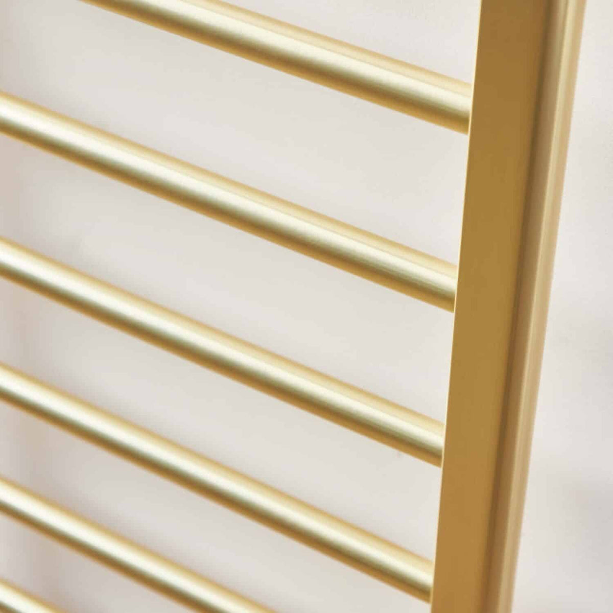 Sleek gold towel radiator in a modern bathroom setup, ideal for heating and towel drying, featuring durable metal construction with a polished finish.