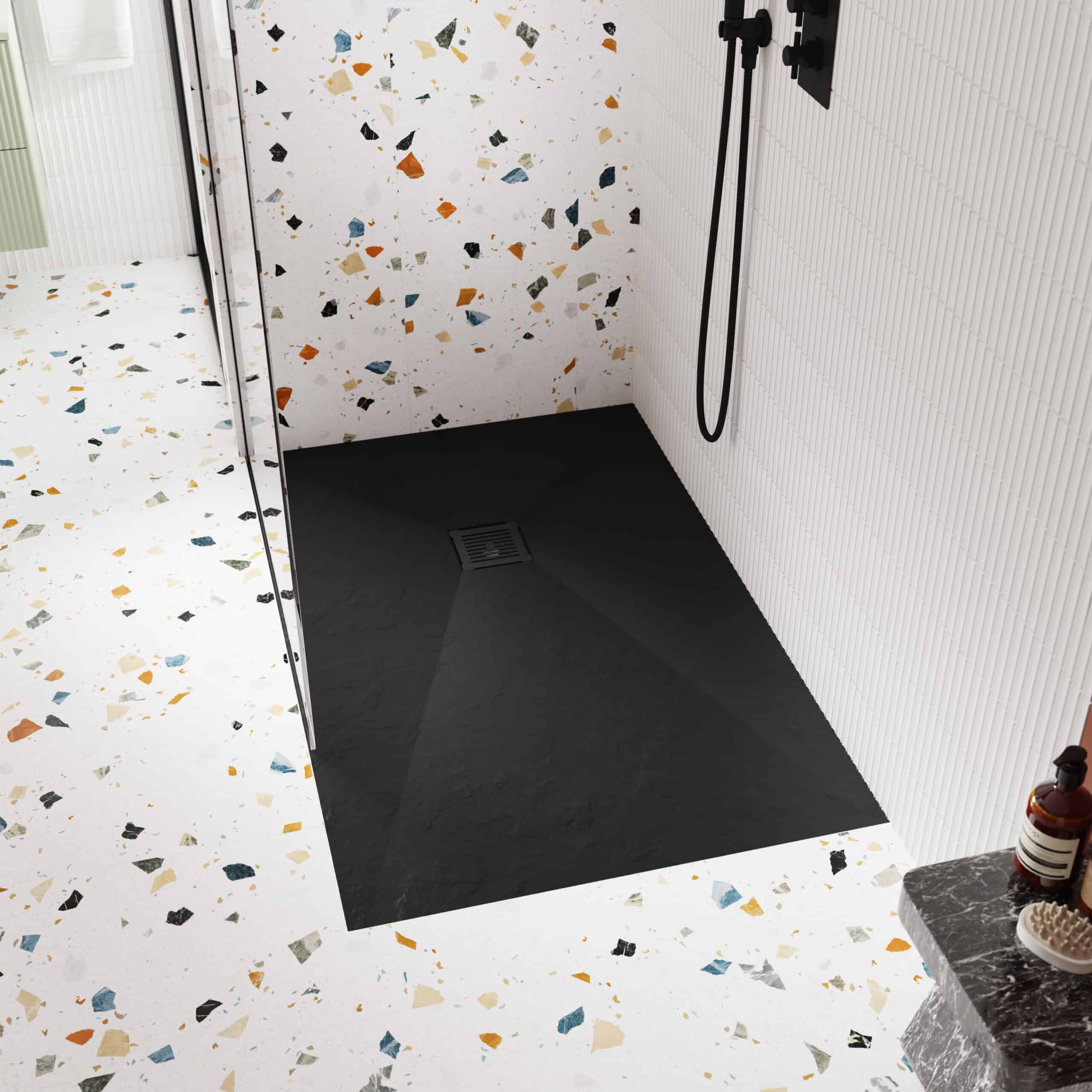 Modern walk-in shower with terrazzo and black slate flooring and contemporary fixtures, featuring a sleek black shower head and textured wall tiles for a stylish bathroom upgrade.