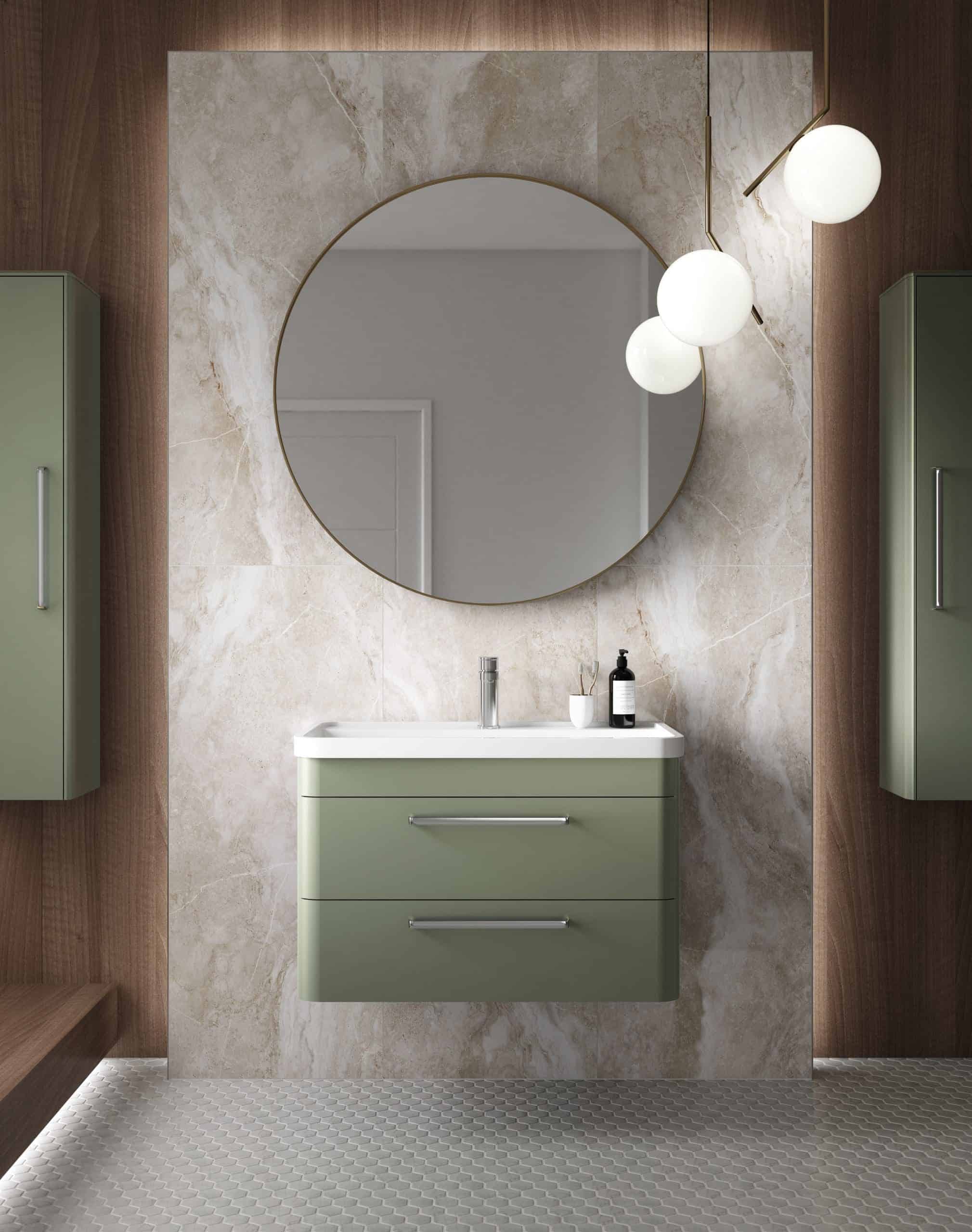 Sleek green bathroom vanity with integrated sink and modern chrome handles, complemented by large circular mirror and stylish lighting fixtures, creating a contemporary bathroom design.