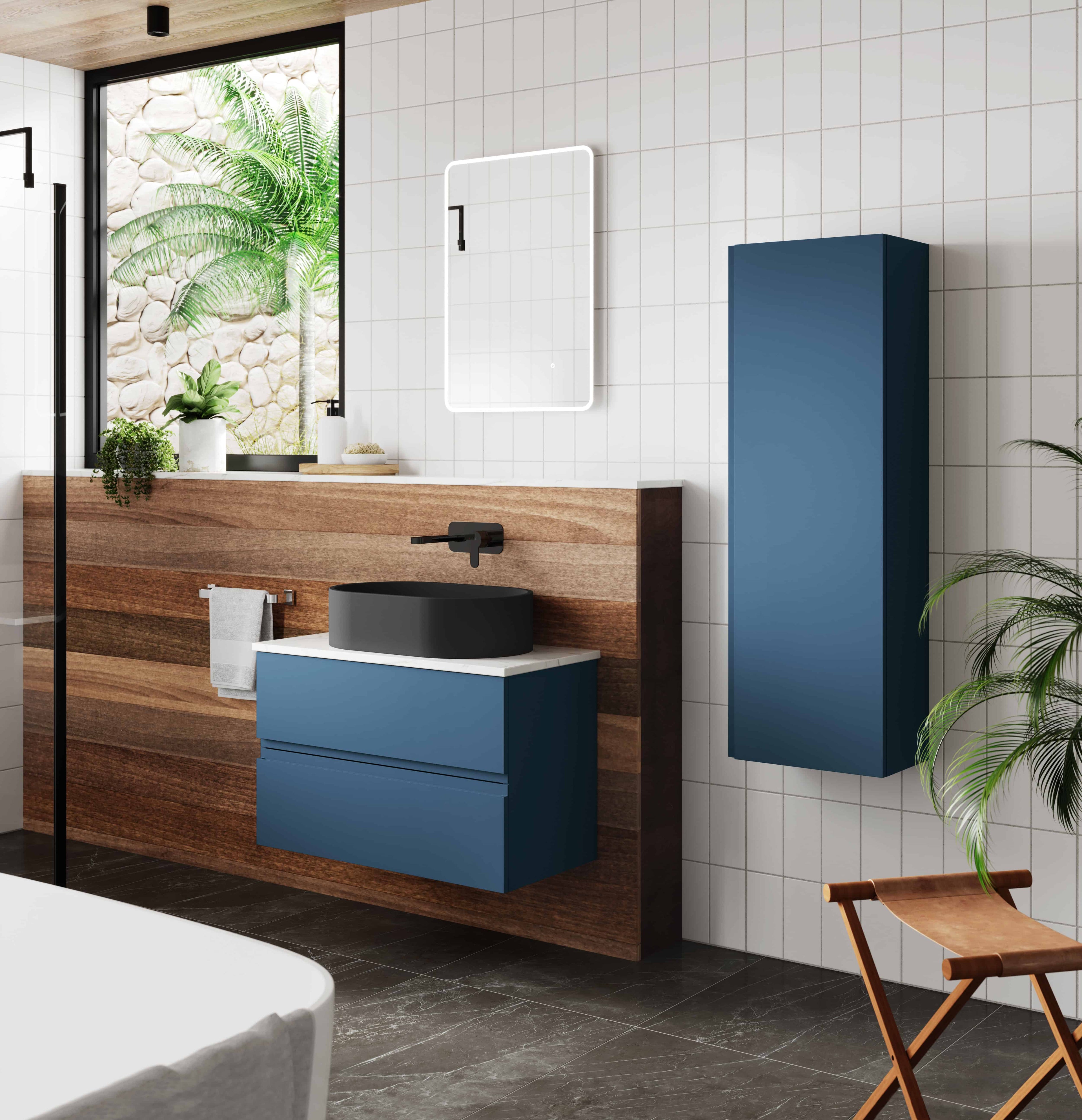 Sleek modern bathroom featuring blue floating vanity with black vessel sink, wall-mounted mirror with integrated lighting, tall blue storage cabinet, and natural wood accents, creating a stylish and functional space.