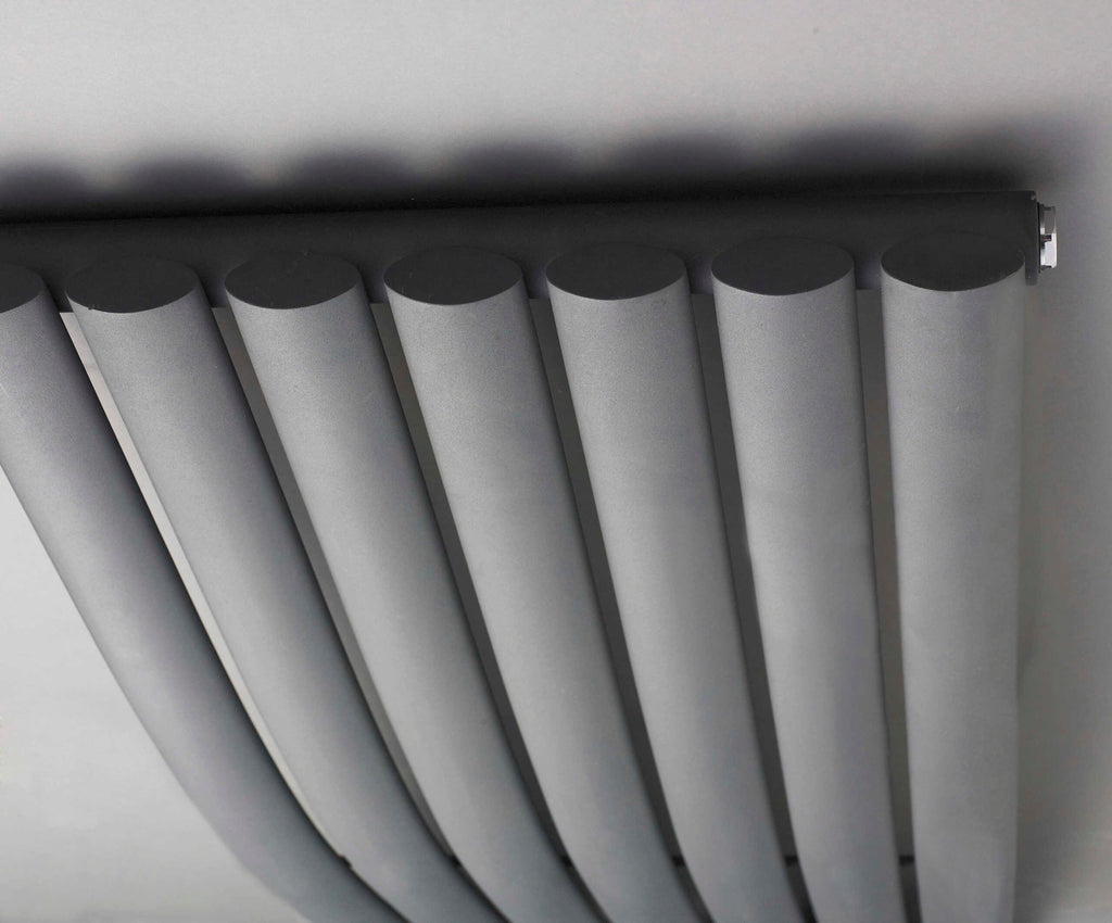 Modern central heating radiator with vertical panels in a contemporary bathroom setting.