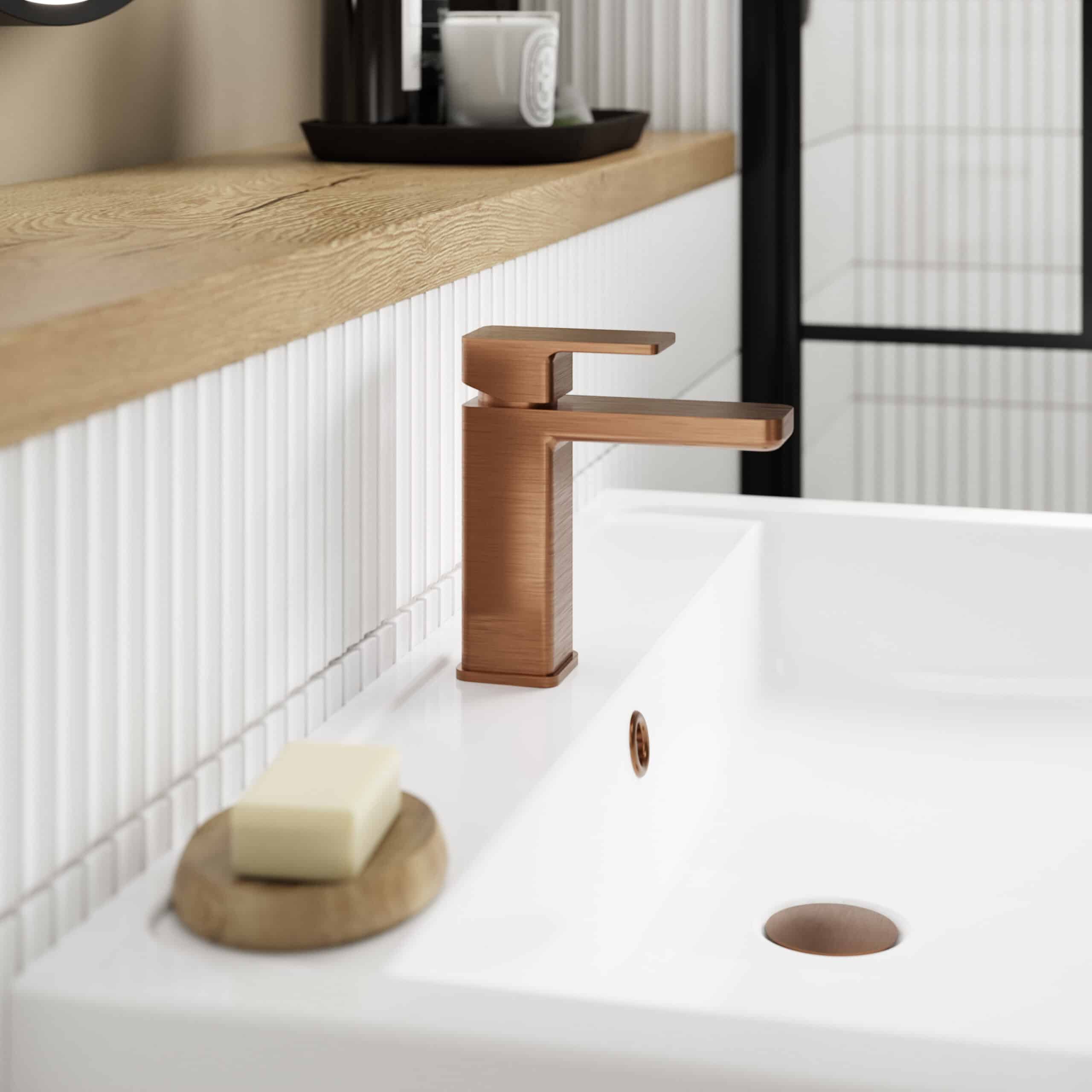 Brushed bronze bathroom sink tap with modern minimalist design, installed on a white ceramic basin in a contemporary bathroom setting.
