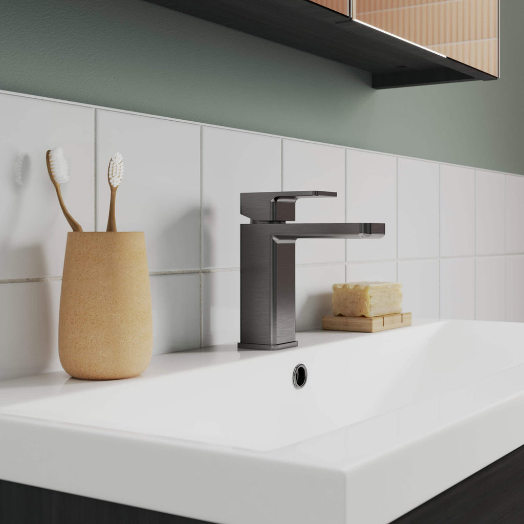 Sleek modern bathroom sink with chrome faucet, beige toothbrush holder, natural soap bar on wooden tray, clean white tiles, minimalist design, perfect for contemporary bathroom decor.