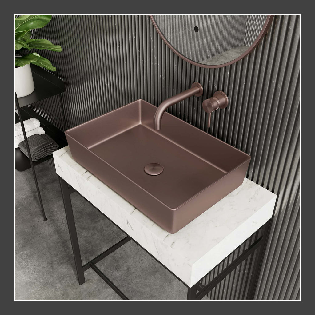 Brushed bronze bathroom sink with modern wall-mounted faucet and round mirror in sleek contemporary bathroom setup.
