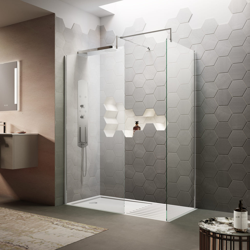 Shower enclosure with white and grey hexagon tiles in a modern bathroom with a glass partition and wall-mounted shower panel.