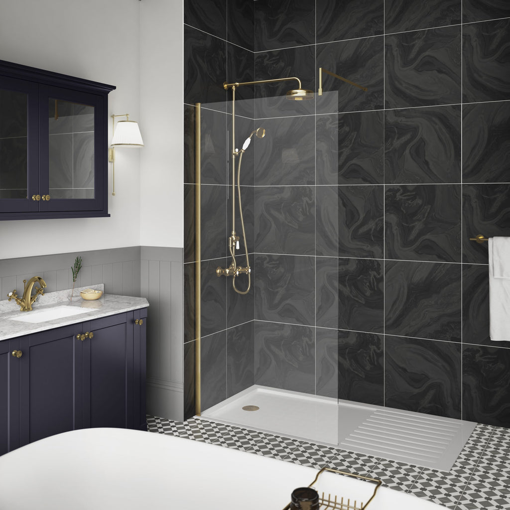 Elegant walk-in shower with black marble-effect tiles, brass fixtures, and a rain shower head, complemented by classic navy blue vanity with marble countertop in luxurious Bubly Bathrooms.