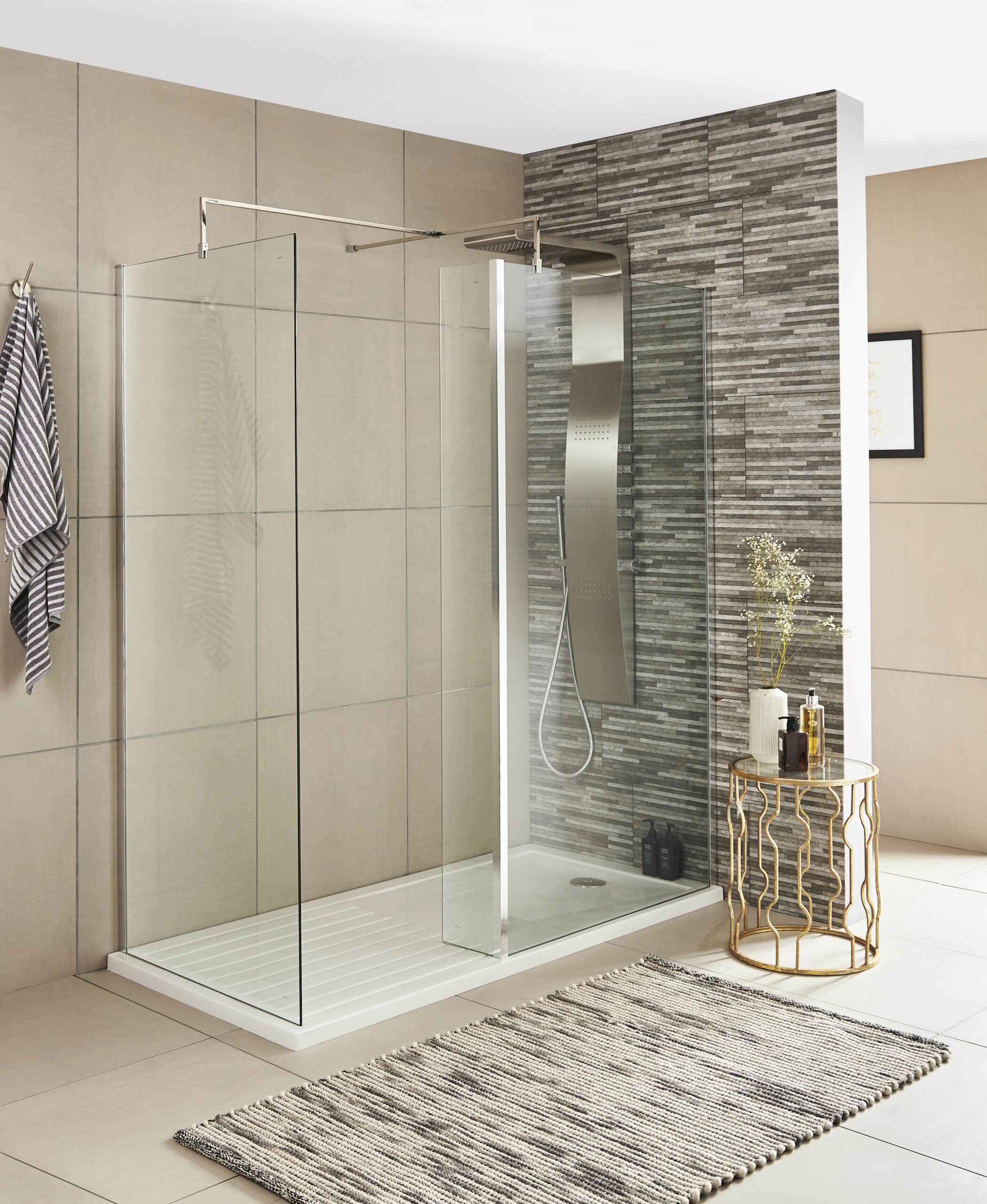 Contemporary walk-in shower with clear glass panels, modern chrome fixtures, and textured grey wall tiles in a stylish bathroom setting.