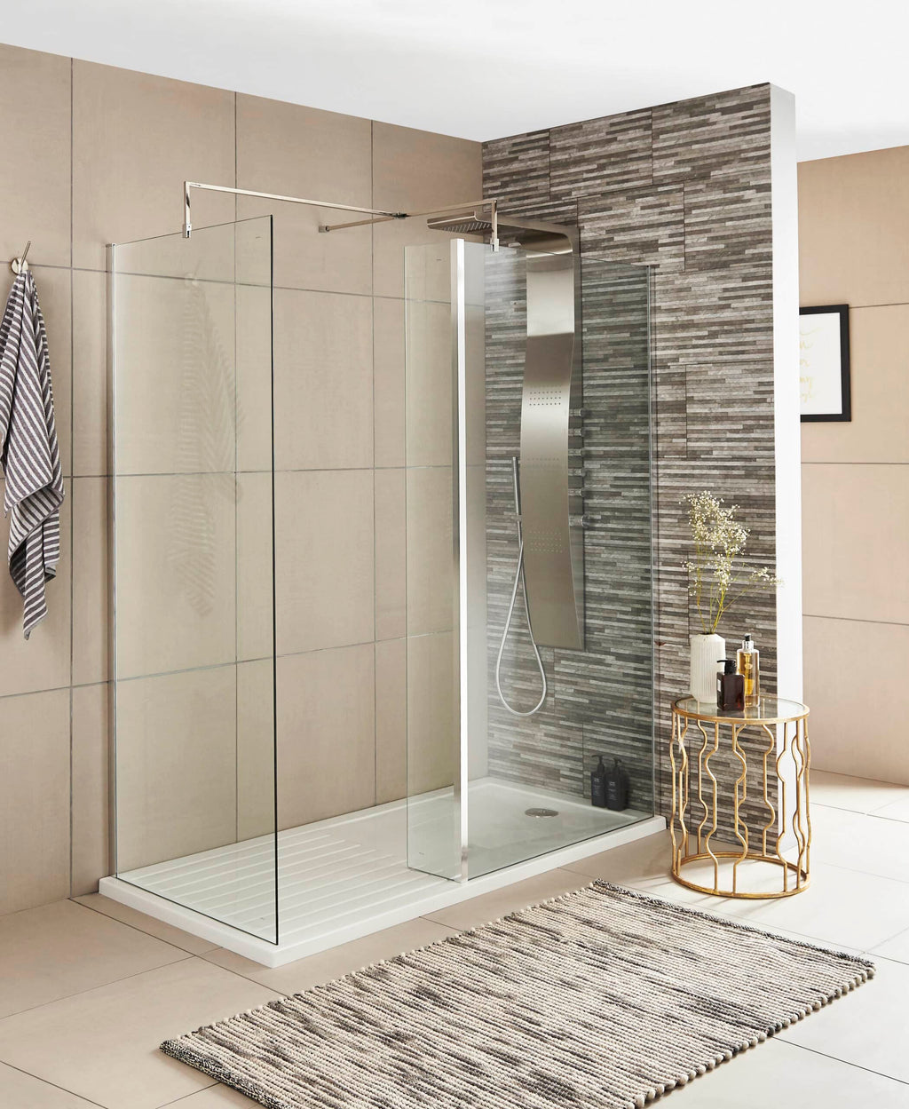 Contemporary walk-in shower with clear glass panels, modern chrome fixtures, and textured grey wall tiles in a stylish bathroom setting.