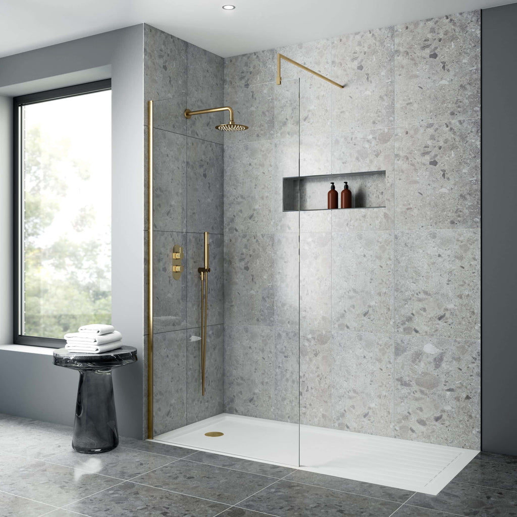 Shower enclosure with modern gold fixtures, grey textured tiles, built-in niche with bath products, large window, and minimalist design perfect for luxury bathroom renovations.