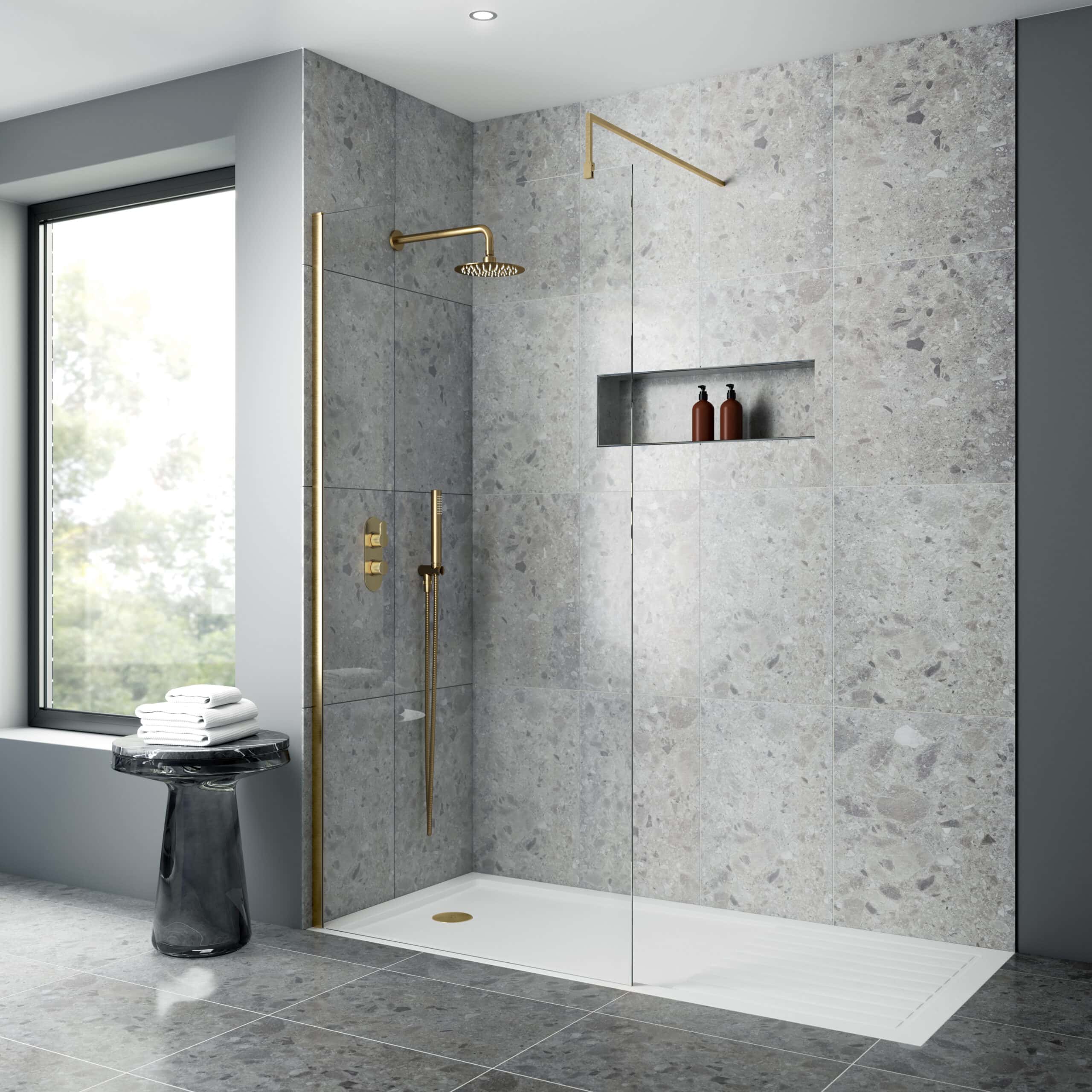 Shower enclosure with modern gold fixtures, grey textured tiles, built-in niche with bath products, large window, and minimalist design perfect for luxury bathroom renovations.