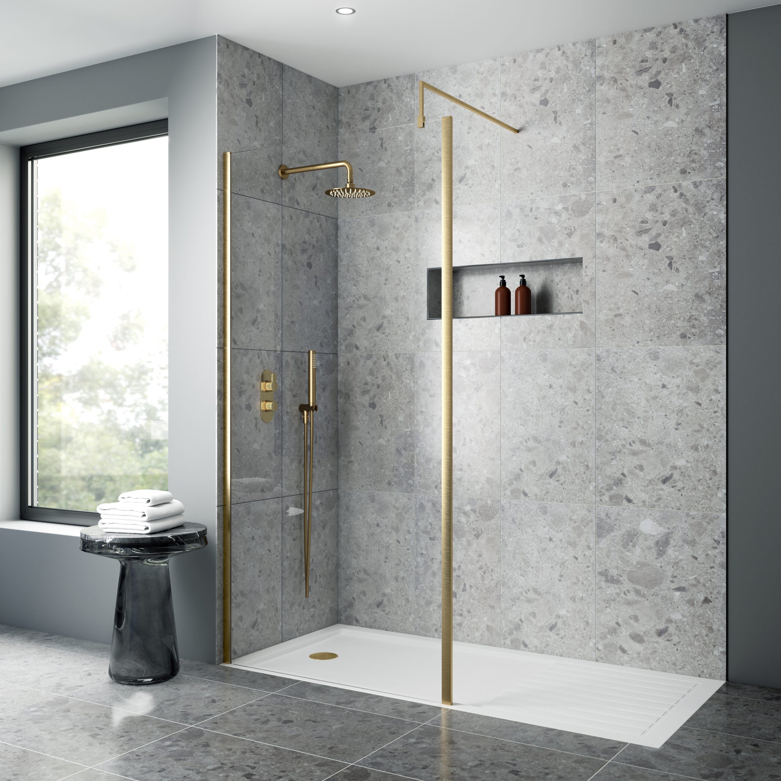 Polished grey stone walk-in shower with gold fixtures, modern showerhead, and built-in shelf, set in contemporary bathroom with large window and minimalist decor.
