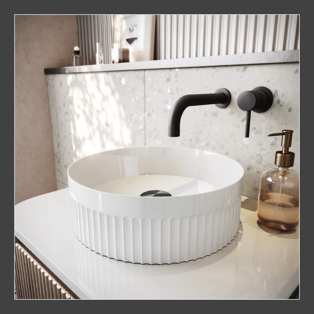 Elegant modern bathroom sink with a sleek black tap and stylish soap dispenser, set against a terrazzo wall with decorative accents, ideal for contemporary bathroom designs.